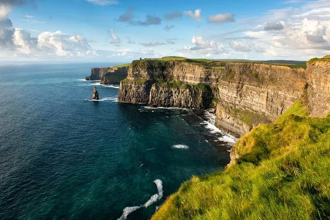 The Cliffs of Moher seen from the clifftop grass, with a sea stack and the Atlantic below